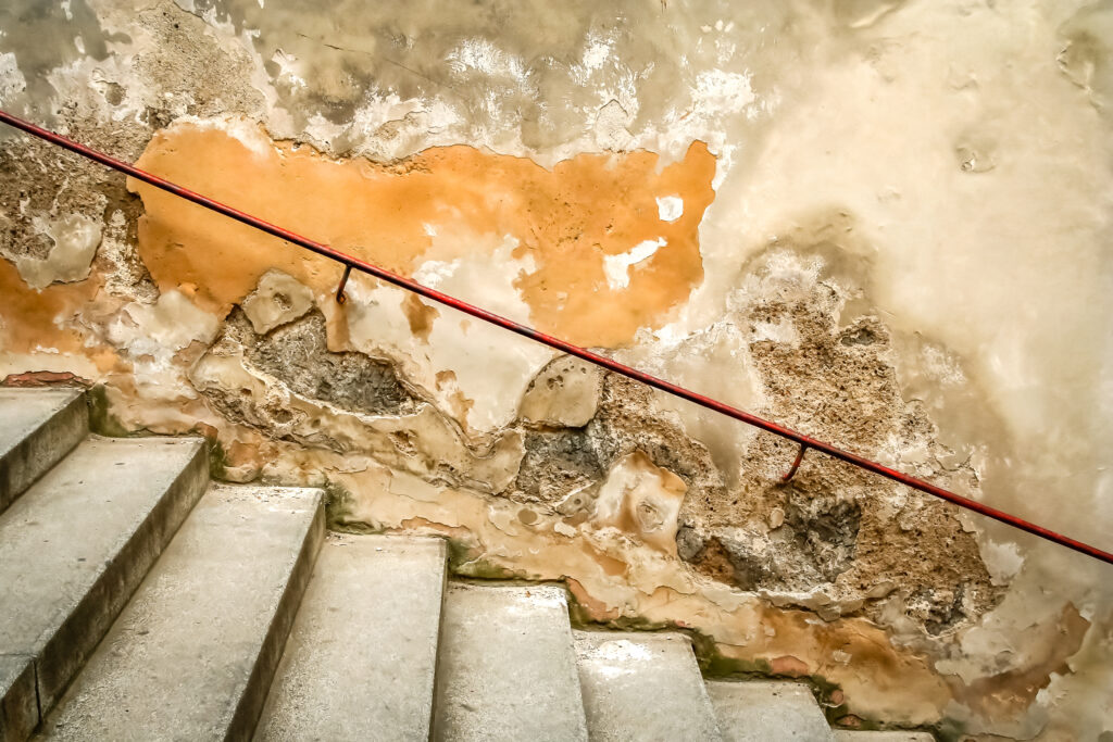 Humedades y desprendimientos en escalera antigua con daños por filtraciones de agua